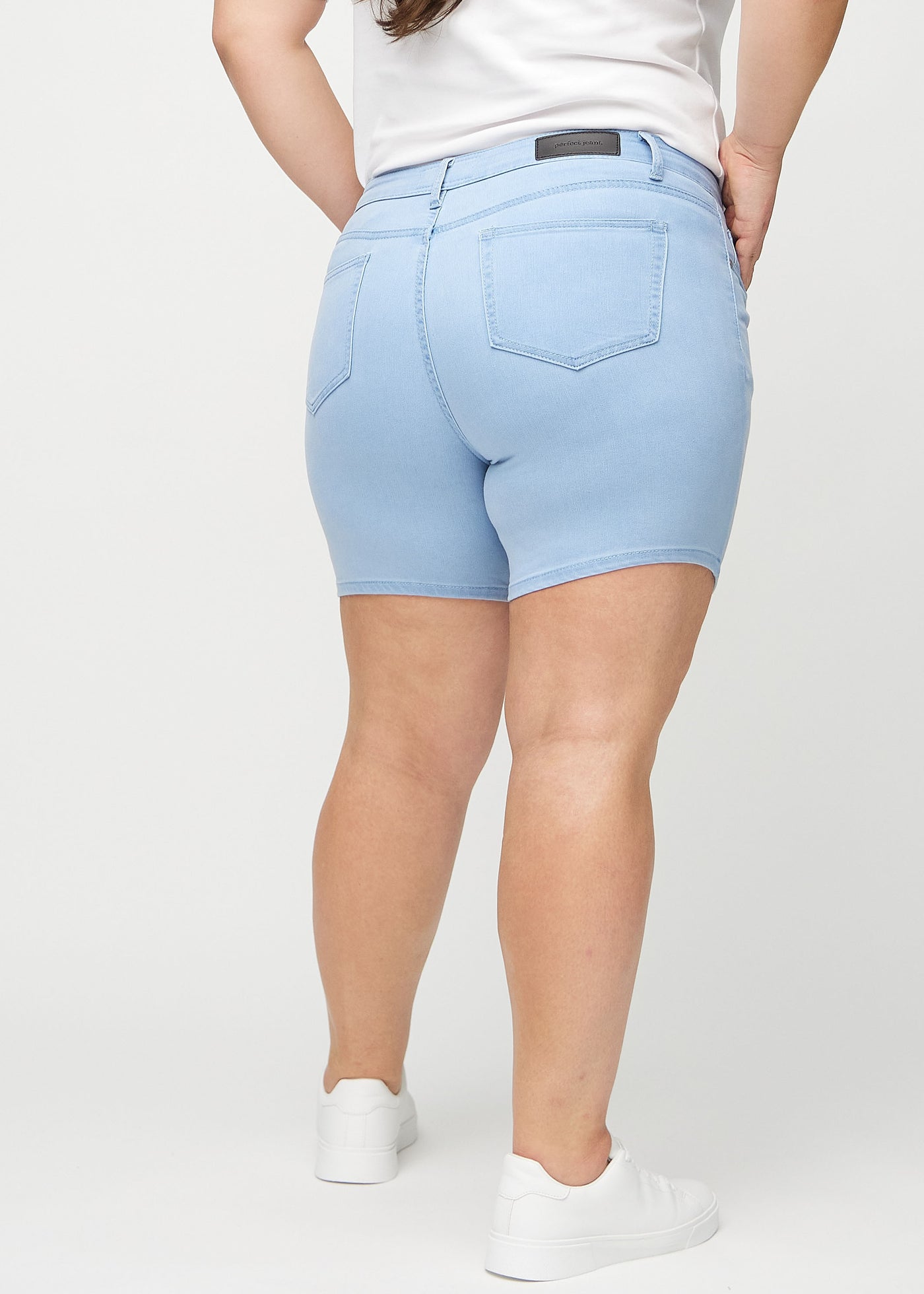 Lyseblå skinny short shorts set bagfra på en plus-size model, så man kan se hele produktet.