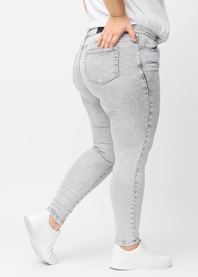 Lysegrå denim skinny jeans set bagfra på en plus-size model, så man kan se hele produktet.