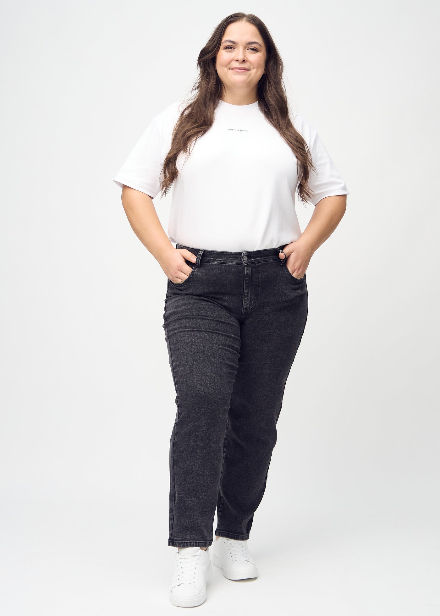 Fuldt billede af en plus-size model i mørkegrå denim regular jeans.