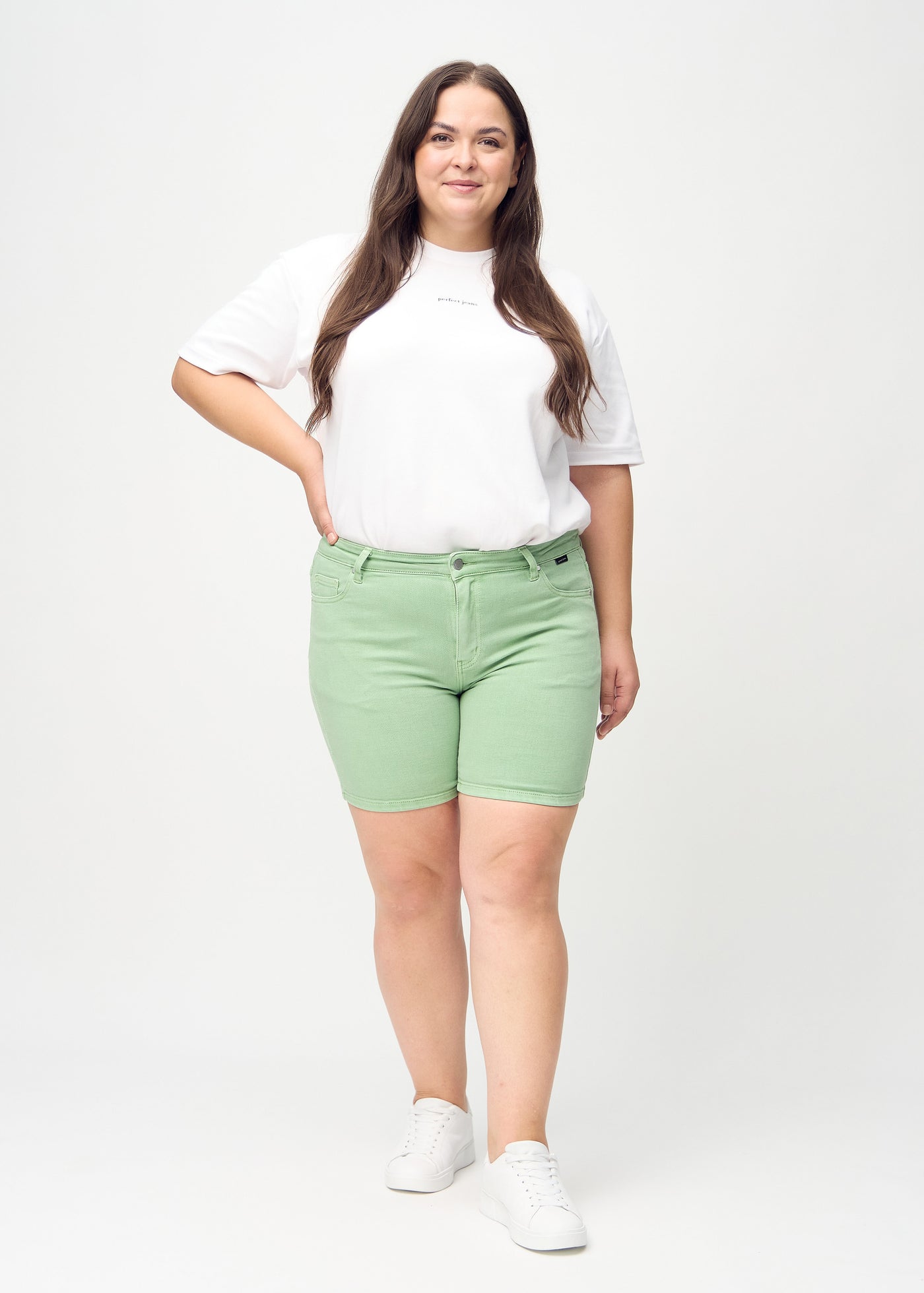 Plus-size model går ind i billedet, strækker i sine shorts, viser dem frem ved at dreje rundt, og forlader derefter billedet.